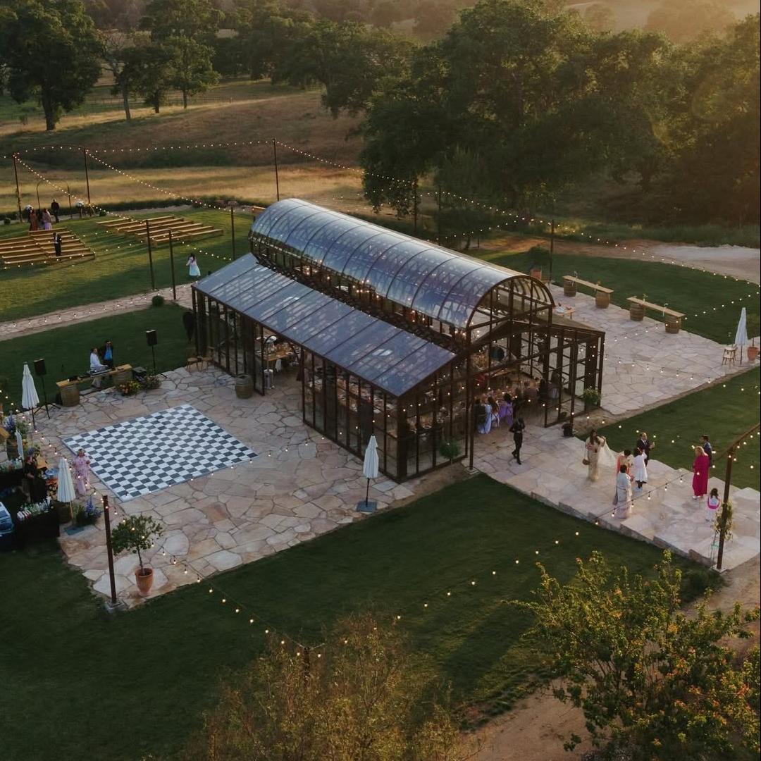 Aerial rendering of the glass house venue with evening lighting and event seating